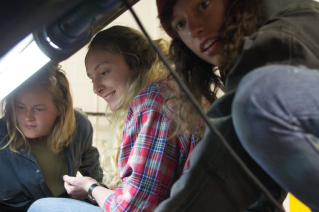 大二学生Charlotte Surface和Corinna Steinrueck以及大四学生Savannah Livengood在学院的汽车商店里制作一辆汽车。